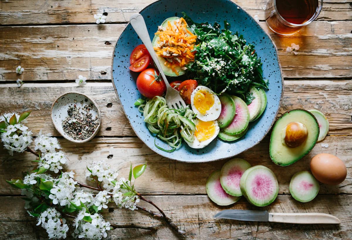 Lifestyle coach en cliënt bekijken samen een eenvoudig weekmenu vol haalbare voedingsgewoontes
