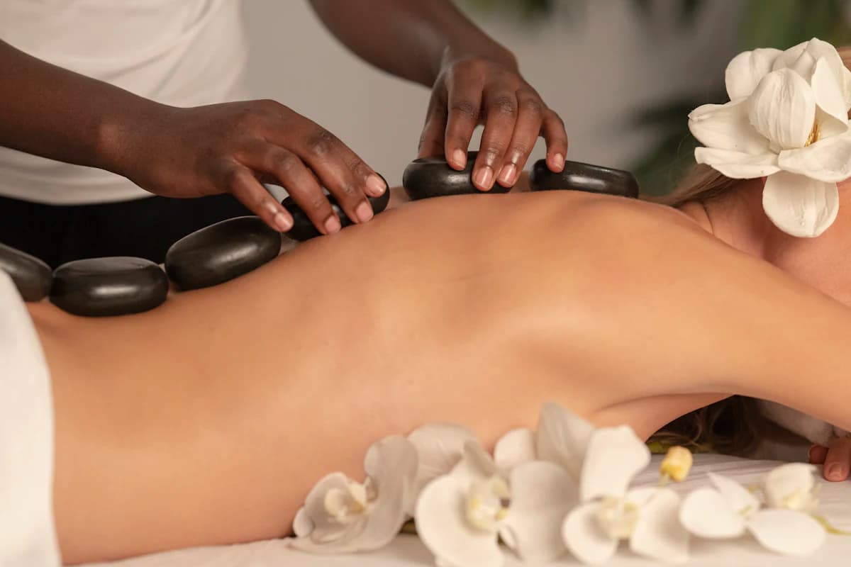 Warme, gladde lavastenen op de rug van een klant tijdens een hotstone massage in een massagesalon