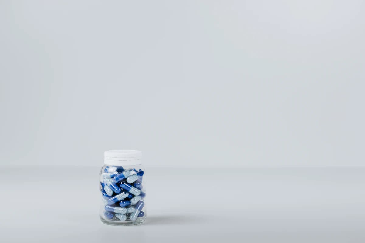Vrouw drinkt rustig een glas water terwijl ze na een massage recht op de rand van de massagetafel zit