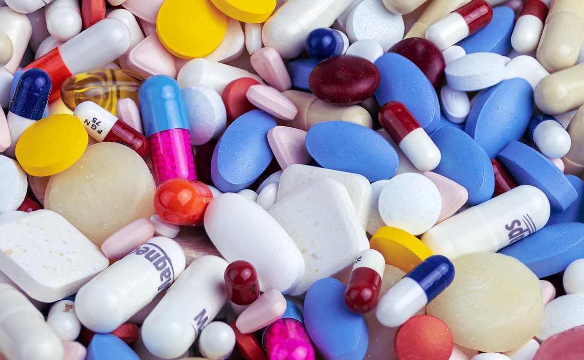 Apotheker bekijkt medicatielijst en supplementenpotjes op een balie