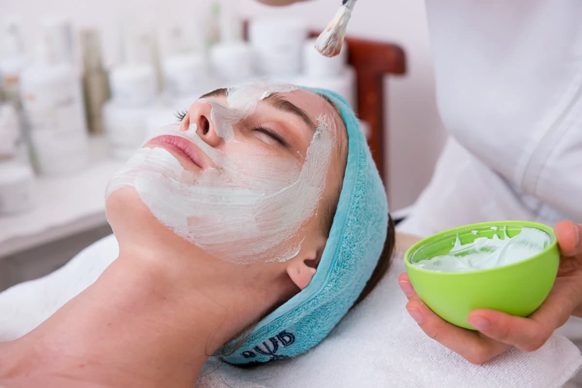 Schoonheidsspecialist behandelt de wang van een cliënt met een dermapen tijdens een microneedling-sessie