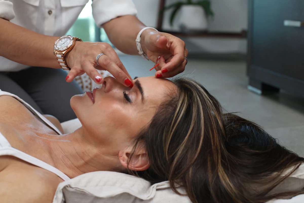 Behandelaar voert RF microneedling uit op de kaaklijn van een cliënt met een radiofrequentie-handstuk