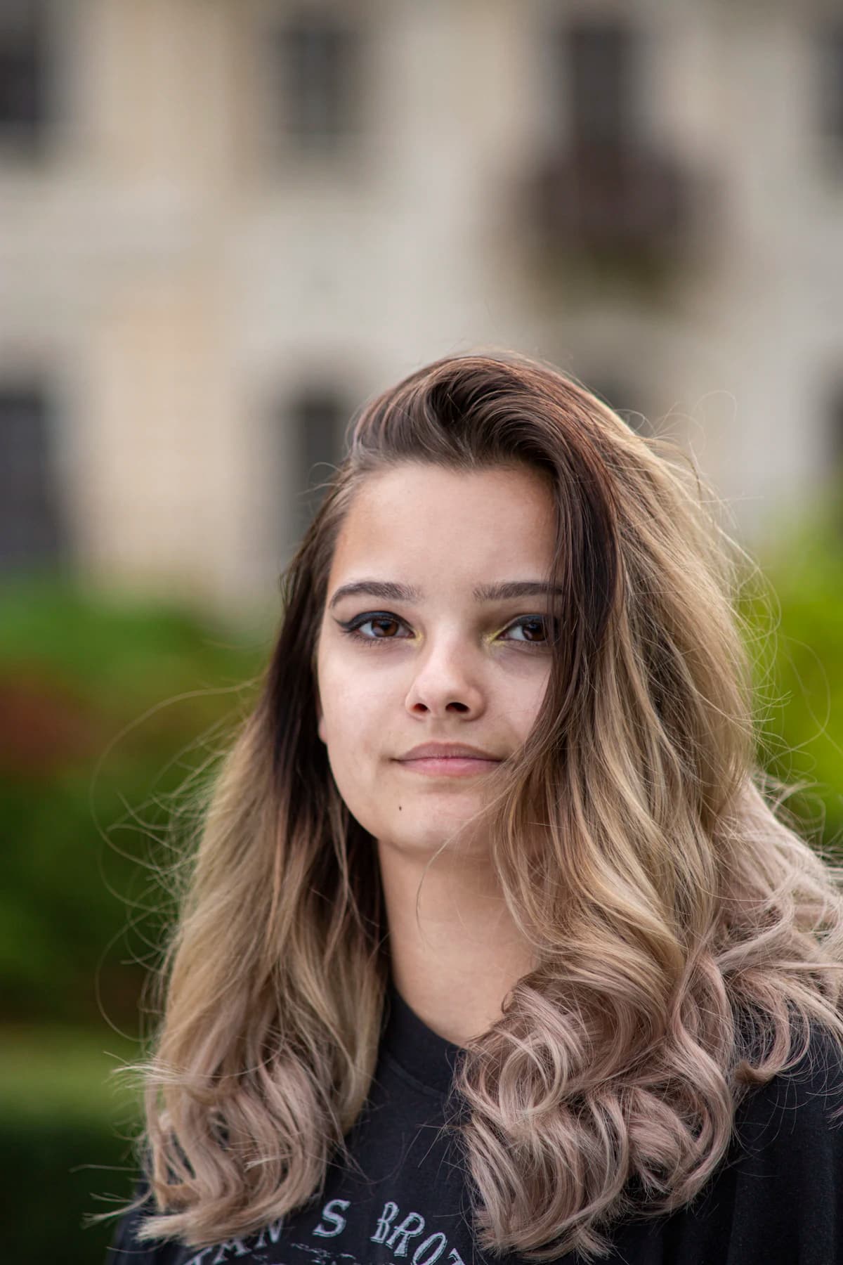 Kind zit lachend in een speciaal kinderstoeltje bij de kinderkapper tijdens het knippen