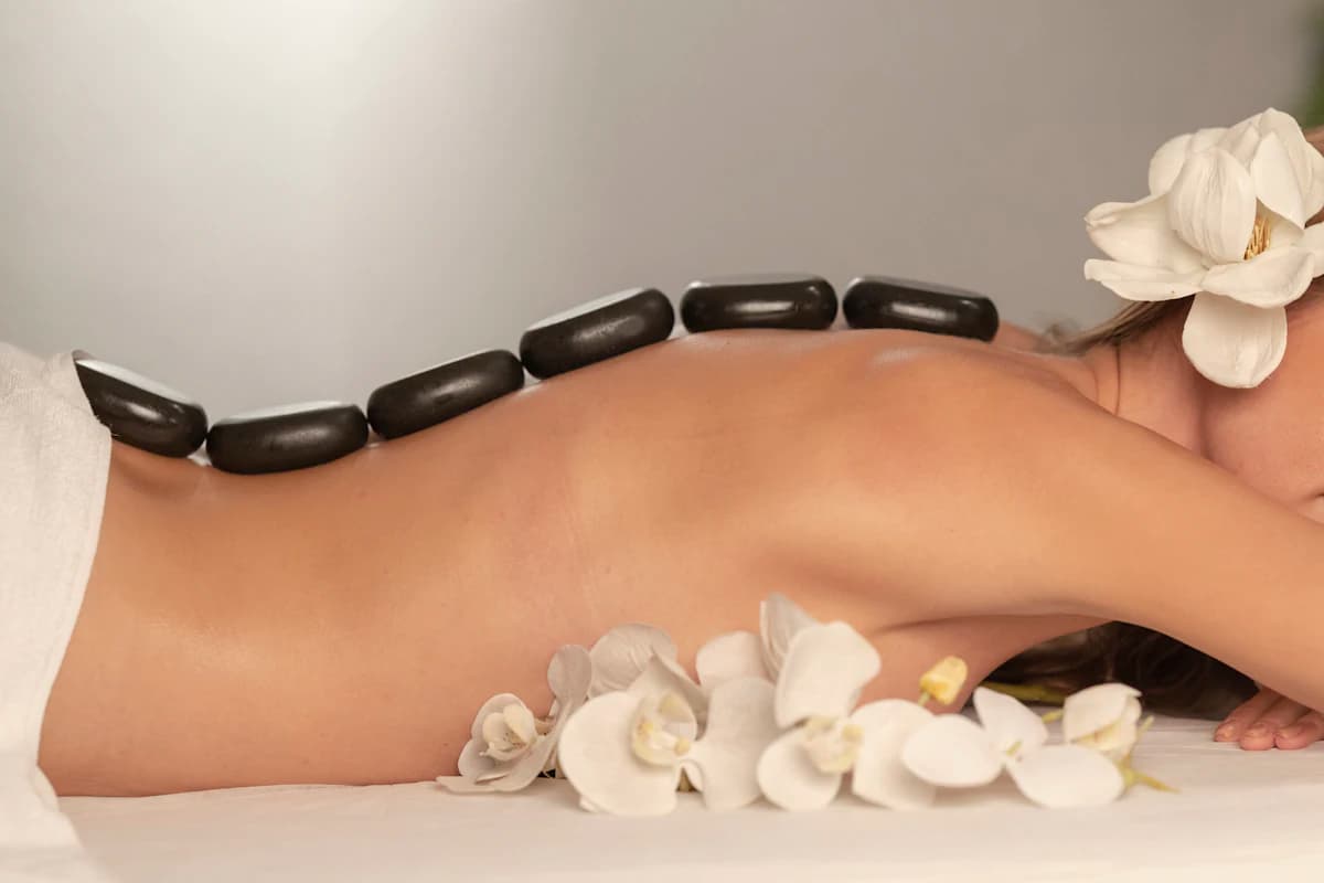 Masseur zet een draagbare massagetafel met lakens klaar in een rustige woonkamer voor een massage aan huis