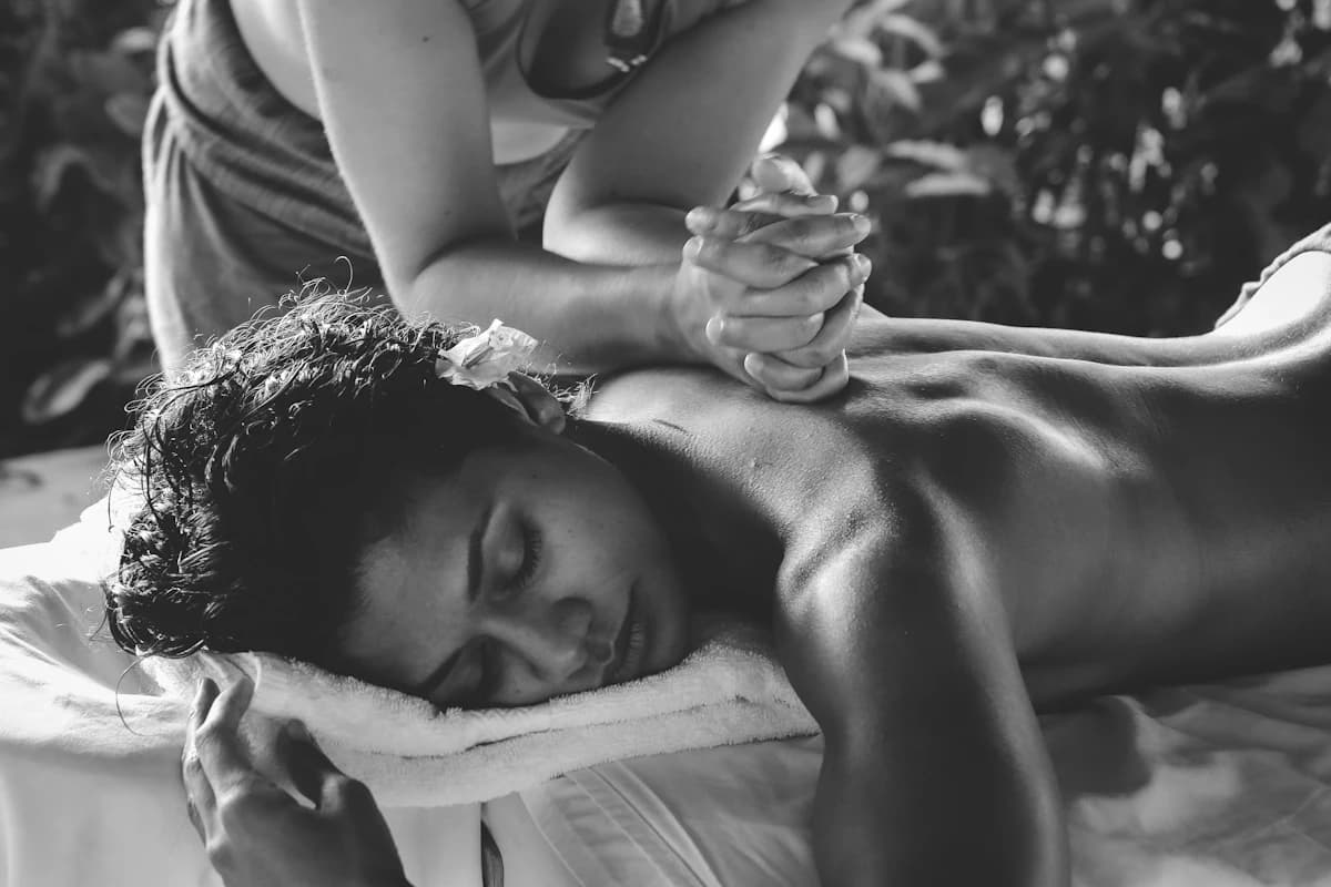 Prijslijst en behandeltafel in een Belgisch massagesalon, met een klant die een afspraak boekt aan de balie