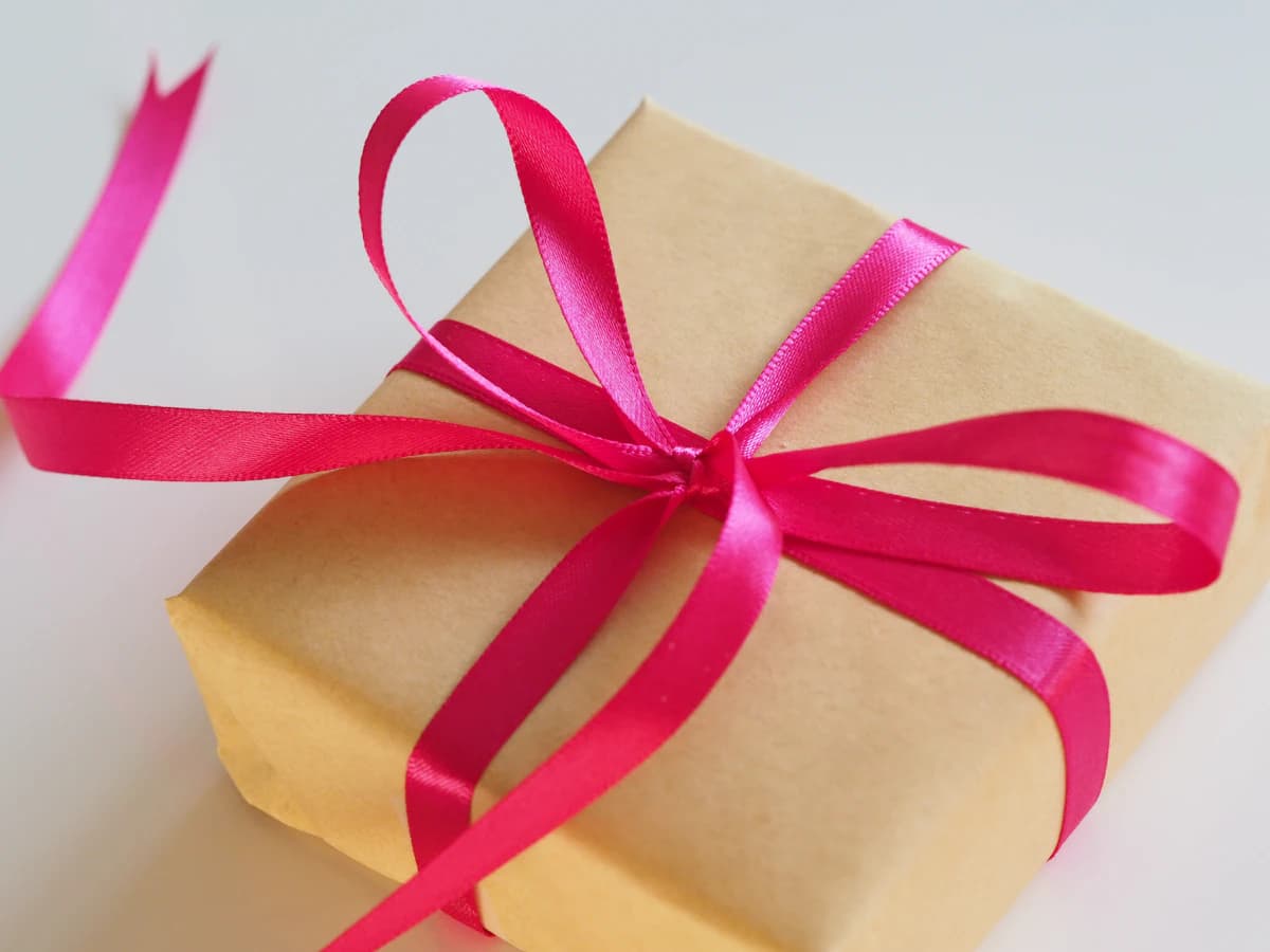 Wellness cadeaubon met lint naast zachte spa-accessoires